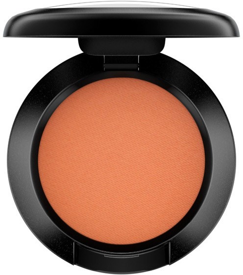 A round blush compact with peach-colored powder inside a black case, with the lid open.