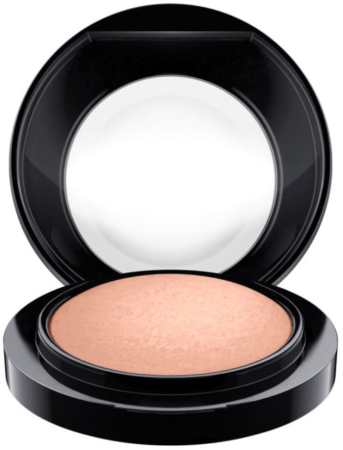 En kompakt makeuppuderbehållare med öppen lock som visar peachfärgad puder. Enkel, svart rund dosa.