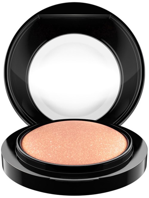 A compact with a light peach-colored, shimmery eyeshadow inside, open to show the product.