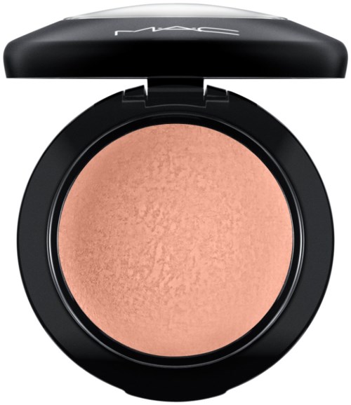 A round makeup blush compact with a beige-colored blush inside and a black lid with the MAC logo.