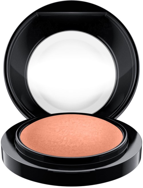 A compact makeup case with a peach-colored powder inside and a mirror on the lid.