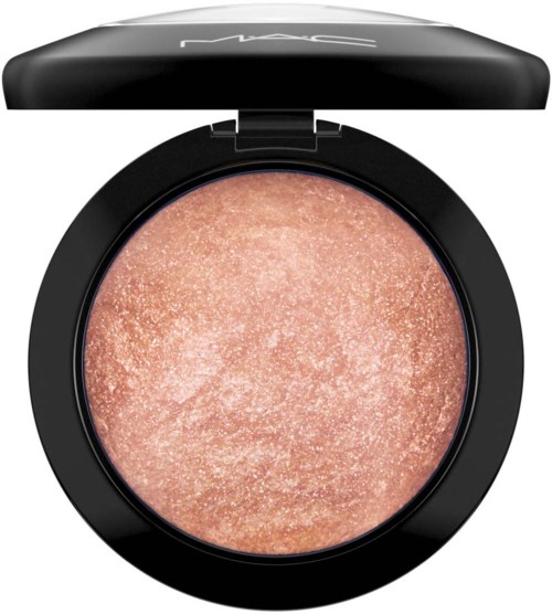 Ein pfirsichfarbiges, schimmerndes Make-up in einem runden schwarzen Behälter mit MAC-Logo auf dem Deckel.