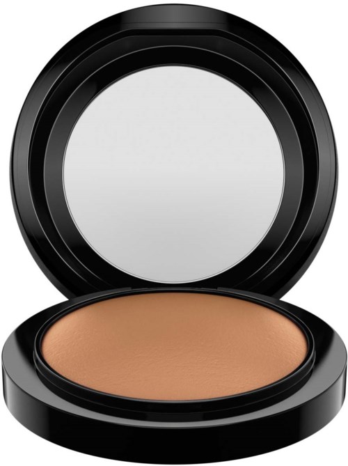 A round compact case with tan face powder inside, black lid open showing a mirror.