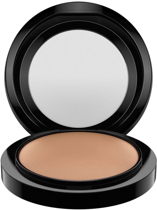 A round makeup compact with beige powder inside and a black lid, open showing the powder.