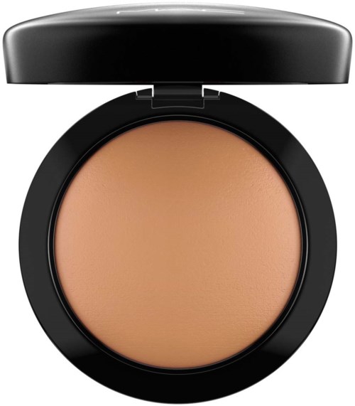A compact with beige makeup product inside, black lid open, simple design. The product appears smooth and creamy.