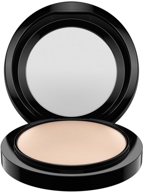A compact with a black circular case and a light-colored powder inside.