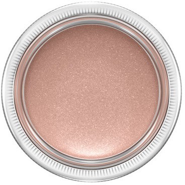 A round container holds a shiny, light pink powder, likely makeup, with a clear lid showing the product inside.