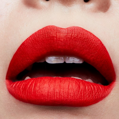 Close-up of lips with bright red lipstick, slightly open showing teeth and part of tongue.
