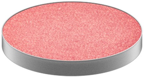 A round, flat object with a pink, textured surface and a silver edge.