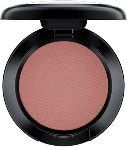 A round makeup blush in a black compact case with a lid. The blush is pinkish-peach in color.