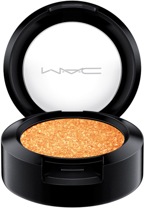 A round black compact with orange glittery eyeshadow. The inside mirror shows the MAC logo.