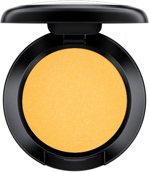 A round black compact holds a bright yellow powder, with a small lid covering it.