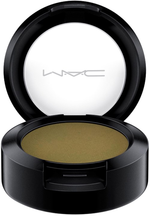 A black makeup compact with a transparent lid shows yellowish-green eyeshadow inside.