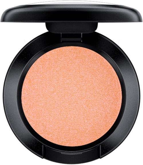 A round, orange blush or eyeshadow in a black compact with a lid open.