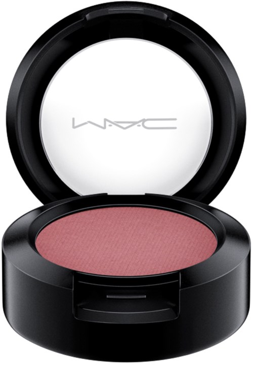 A round makeup blush in a black container with a clear lid, labeled MAC, with pink powder inside.