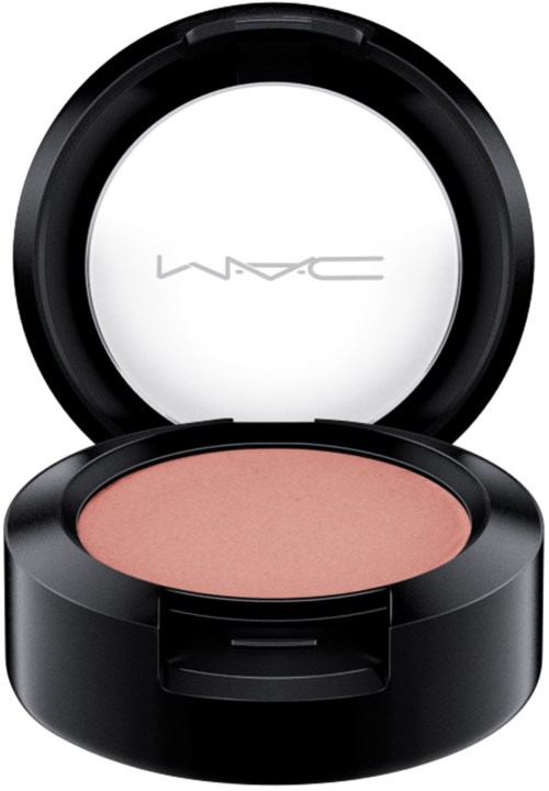 A round black makeup compact with a mirror, containing pinkish-beige blush powder.