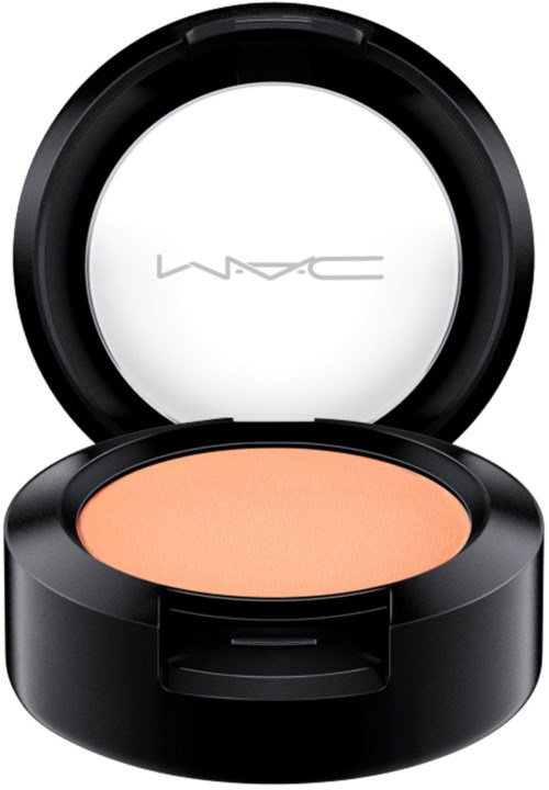 A round makeup compact with a mirror and peach-colored powder inside.