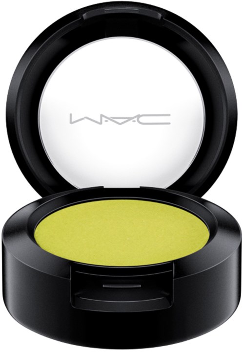 A black compact makeup container with a yellowish-green product inside and a white lid with 'MAC' logo.