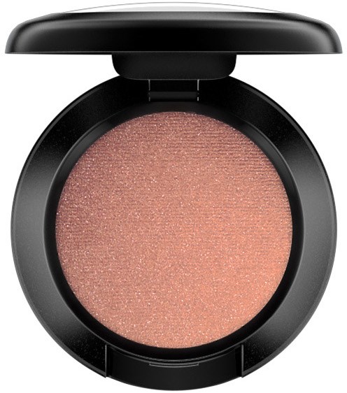 A round makeup compact with pinkish beige shimmery powder inside, and a black lid on top.
