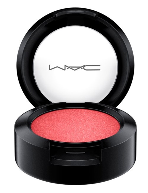 A round makeup compact with pink blush inside and a lid that has 'MAC' written on it.