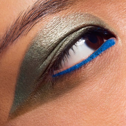Close-up van een oog met groene oogschaduw en een felblauwe eyeliner eronder.