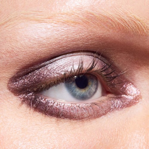 Lähikuva sinisestä silmästä meikillä, mukaan lukien silmäluomen varjostus ja eyeliner, ympäröivät iho ja silmäripset.