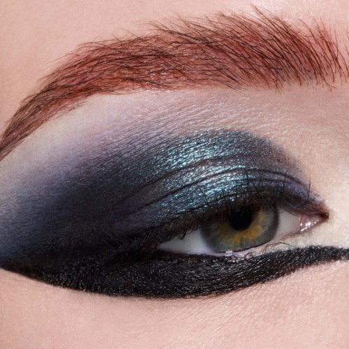 Lähikuvassa silmämeikki, jossa on kiiltävää sinistä ja mustaa, ja paksu musta eyeliner.
