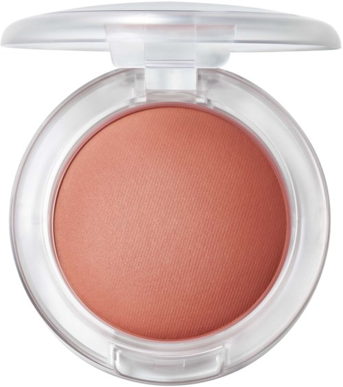 A round, open container of peach-colored blush or powder with a clear lid.