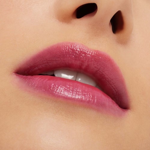 Close-up of lips with pink lipstick, slightly parted, revealing white teeth.
