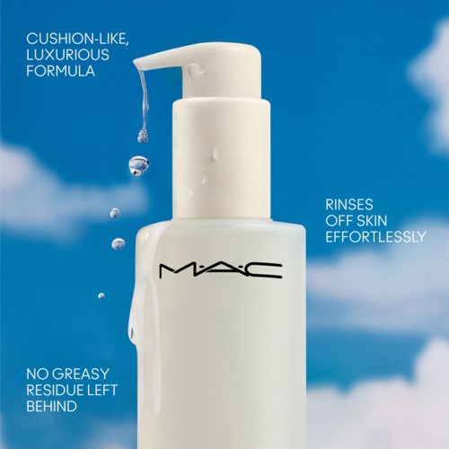 A white bottle with a pump, labeled MAC, against a blue sky with clouds, promoting skin care benefits.