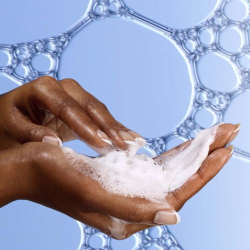 Hands washing with soap and bubbles, with soap bubbles in the background.
