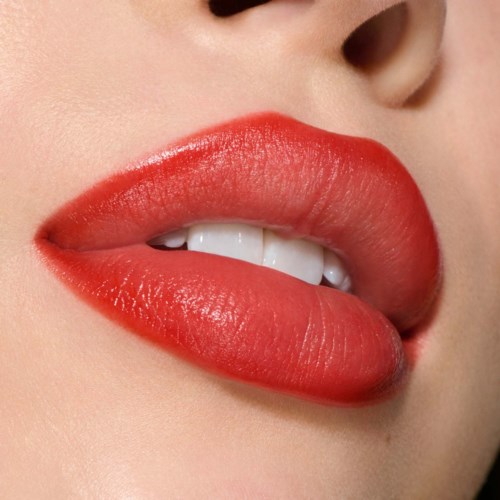 Close-up of lips with shiny red lipstick, slightly parted showing teeth and tongue.