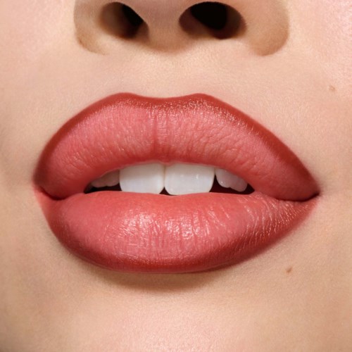 Close-up of lips with soft pink lipstick, slightly parted showing teeth.