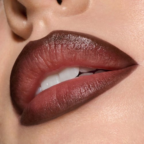 Close-up of lips with shiny, dark lipstick and teeth showing slightly.