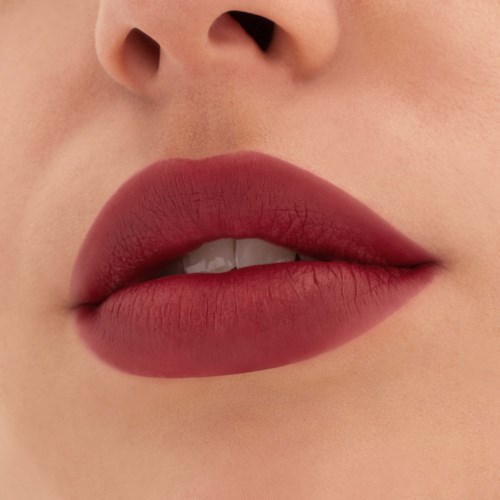 Close-up of lips with pink lipstick and slightly parted teeth.