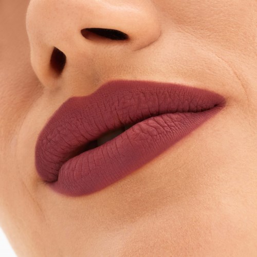 Nahaufnahme von den Lippen einer Frau mit mattem Lippenstift, zeigt natürliche Hautstruktur.