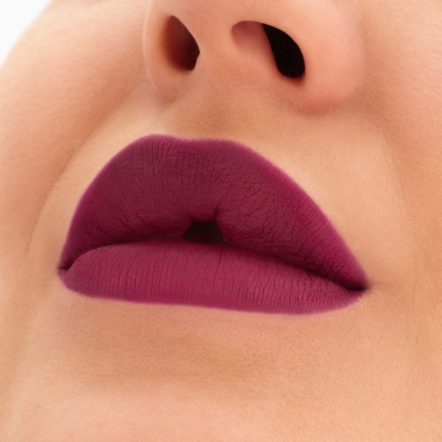 Nahaufnahme von Lippen mit dunkellila Lippenstift und kleiner Lücke. Haut um die Lippen ist hell.