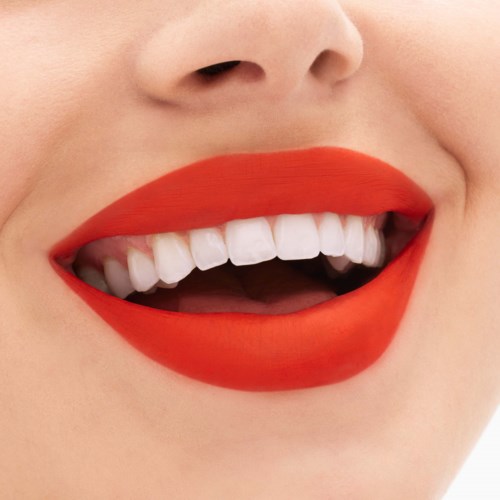 Lächelnder Mund mit knallrotem Lippenstift und weißen Zähnen. Nahaufnahme von Lippen und Zähnen, fröhlicher Ausdruck.