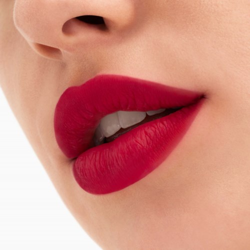Nahaufnahme von Lippen mit rotem Lippenstift, leicht geöffnet, zeigt Zähne, glatte Haut.