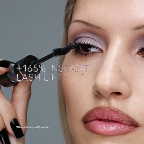 Applying mascara to upper lashes for a 165% instant lift, focusing on eye makeup. No text or logos visible.