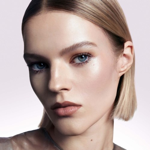 A young woman with fair skin, straight blonde hair, and blue eyes looks directly at the camera with a serious expression.