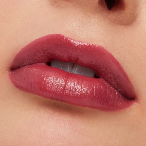 Close-up of lips with pink lipstick, partly open showing teeth, smooth skin around lips.