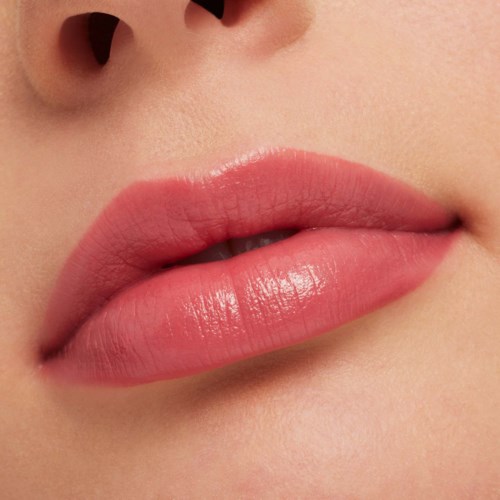 Close-up of full, pink lips with a glossy finish, showing part of the nose.