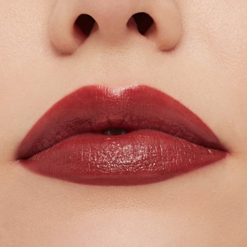 Close-up of lips with deep red lipstick, slightly parted, showing a hint of teeth, and a bridge of a nose.