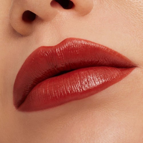 Close-up of lips with shiny red lipstick and smooth skin around.