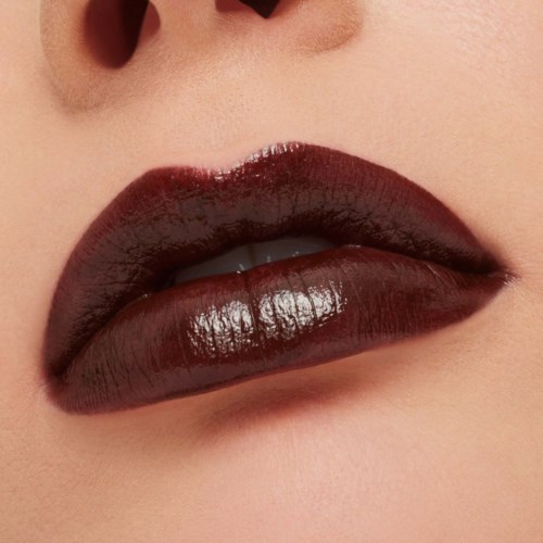 Close-up of lips with shiny dark red lipstick. Part of nose visible above the lips.