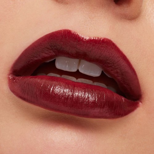 Close-up of lips with dark red lipstick, slightly open showing teeth.