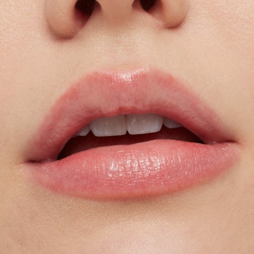 Close-up of lips, partly open, showing upper teeth and pink, smooth skin.