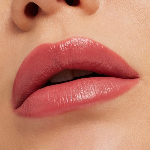 Close-up of lips with glossy, pink lipstick and part of the nose visible.