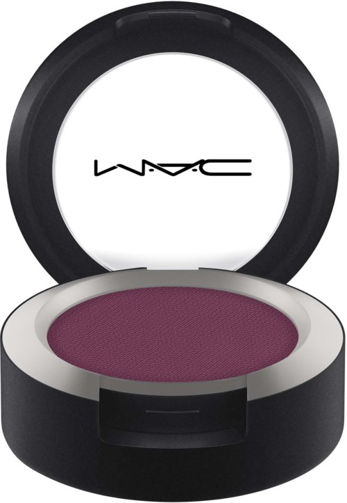 A round black container with a white interior, opening to reveal purple eyeshadow and a MAC logo on the lid.